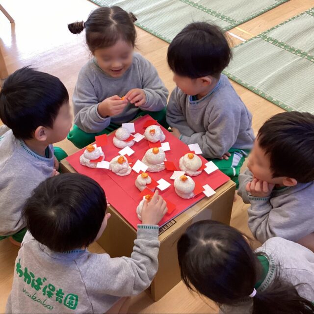 🎍新年に向けての準備が整いました🎍今年も残すところあとわずかとなりました。わかば保育園では、子どもたちと一緒に新しい年を迎える準備を行いました✨まずは12月23日に行った「おもちつき」です。薪で火を焚き、蒸気が上がる中でお米を蒸らす本格的なおもちつき！先生たちが杵でつく姿を、子どもたちは「がんばれー！」「よいしょー！」と元気いっぱいの掛け声で応援してくれました💪5歳児さんは、蒸し上がったばかりのもち米をひと口試食。「いつものごはんと違う！」「あまーい！」と、香りを嗅いだり味わったり、五感で違いを楽しんでいました😊つきあがったお餅は、3歳児以上のクラスで「鏡もち」として丸めてもらいました。自分たちで形を整えた鏡もちは、どれも愛らしく、誇らしげにクラスに飾られています。でも、それだけでは歳神様はやってきません。最後はみんなで「大掃除」です🧹✨「きれいになーれ！」と声を掛け合いながら、毎日使っている椅子を一生懸命に拭き掃除。床掃除では、一列に並んで「せーの！」の合図で一斉に雑巾がけ！みんなで同じ方向に進むことを遊びのように楽しんでいました。「ピカピカになったよ！」と見せてくれる子どもたちの表情は、とても晴れやかでした✨これで、歳神様を迎える準備は万端です。皆さまも、どうぞ良いお年をお迎えください。#わかば保育園 #大阪市 #生野区 #社会福祉法人 #認可保育園 #おもちつき #鏡もち #食育 #もち米 #大掃除 #雑巾がけ #新年の準備 #歳神様 #日本の文化 #冬の行事